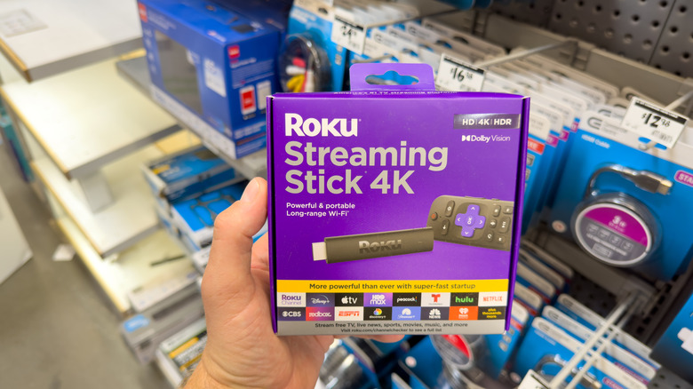 A person holding a Roku streaming Stick box at a store