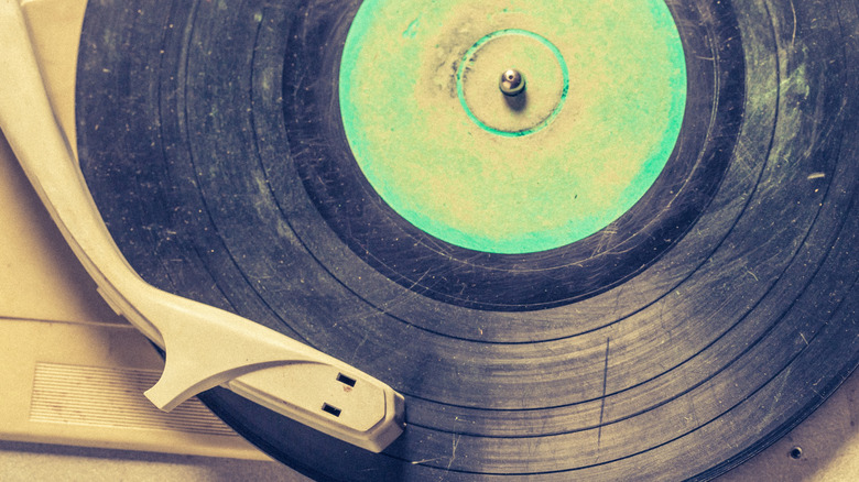 A scratched and worn-out vinyl record on a record player