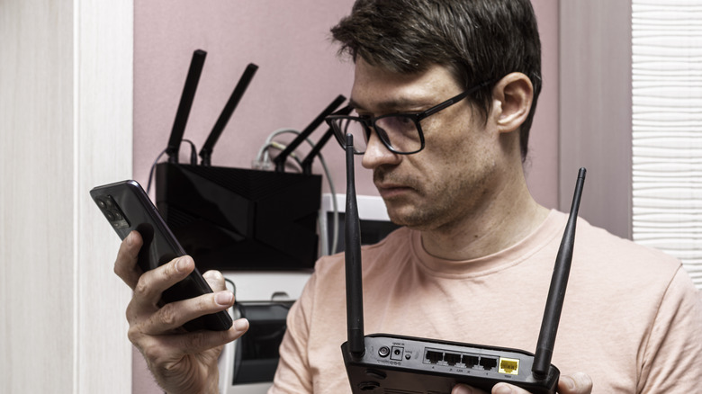 man troubleshooting router setup on phone