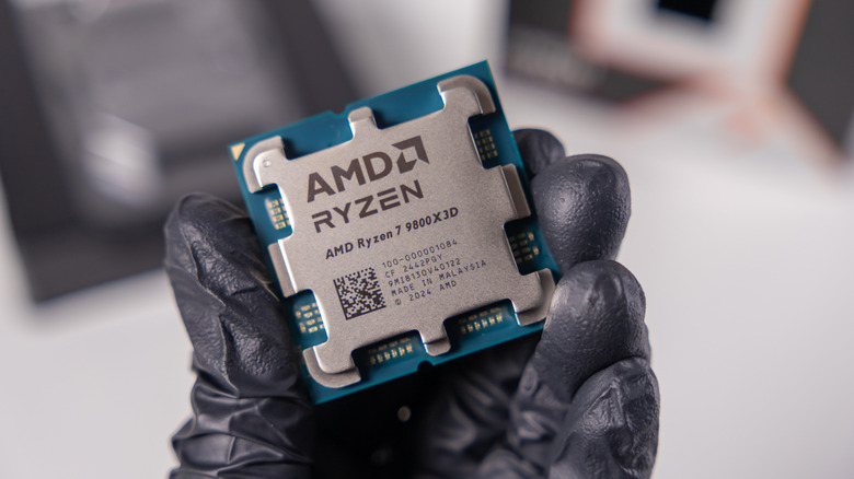 AMD Ryzen 7 9800X3D processor held in a gloved hand
