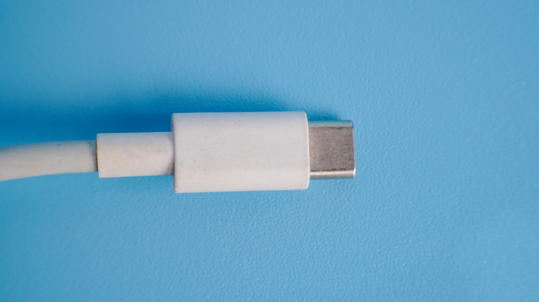 USB-C cable connector shown close-up on a blue surface
