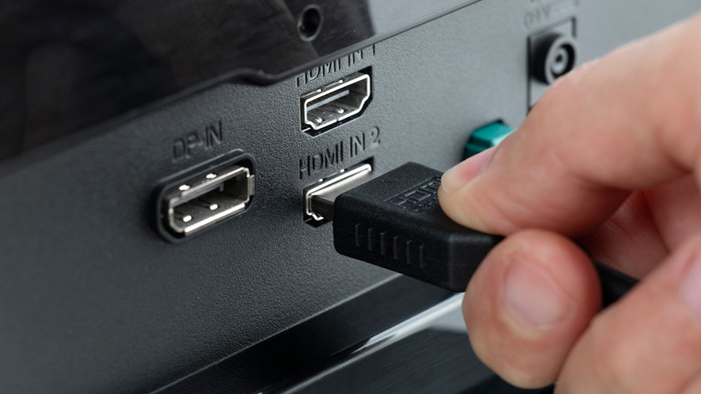 Ac HDMI cable being plugged into a port on a display.