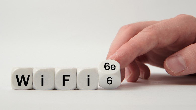 Wi-Fi 6E label spelled out on dice with hand turning them.