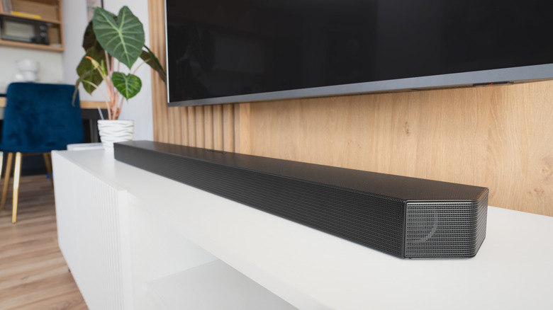 A home theater soundbar connected to a wall-mounted TV.