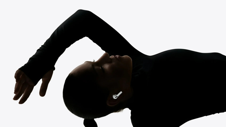 A woman wearing AirPods Pro 3 and dancing