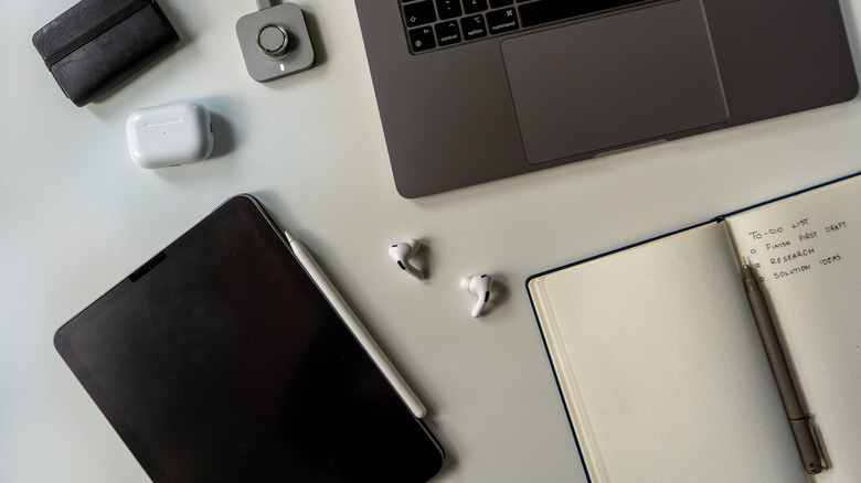 Earbuds and a bunch of other tech accessories sitting on a desk