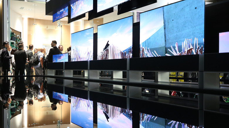 People watching the LG Signature OLED R rollable televisions at the LG booth at CES 2020