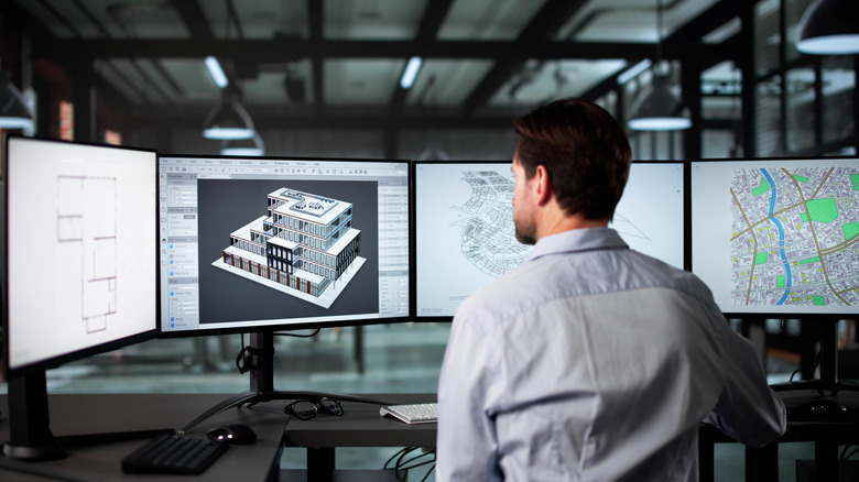 a person working on a project using multiple monitors