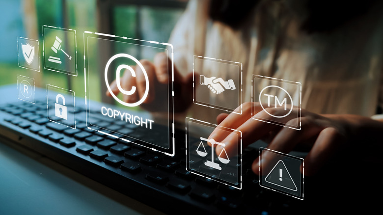 the copyright symbol in holographic form hovering over a person's hands on a keyboard