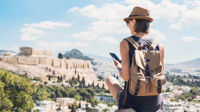 A traveler using her phone outdoors