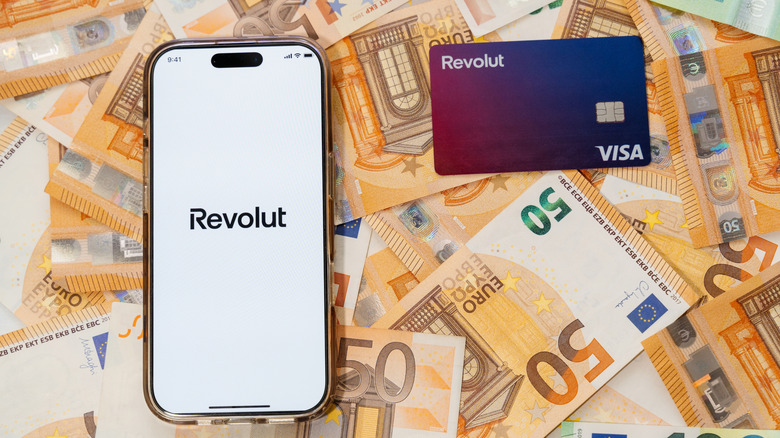 Revolut icon on an iPhone next to a Revolut VISA card