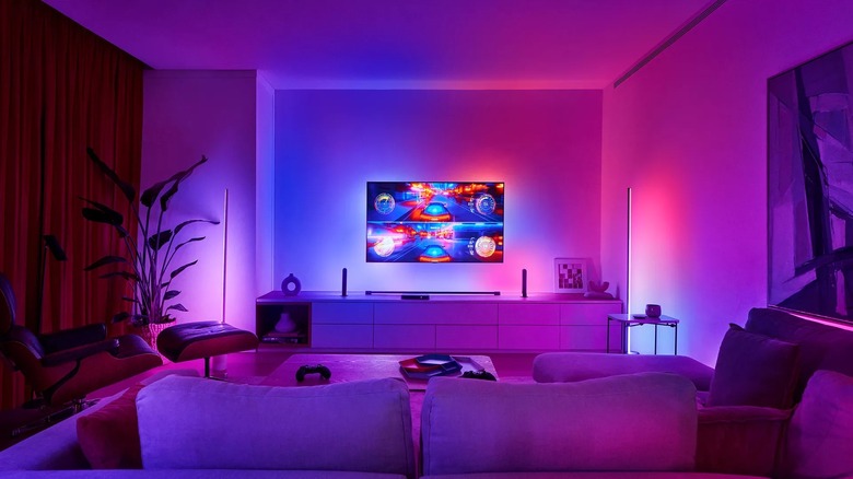 Philips Hue Play HDMI Sync Box 8K on TV stand with Philips Hue lights in the living room