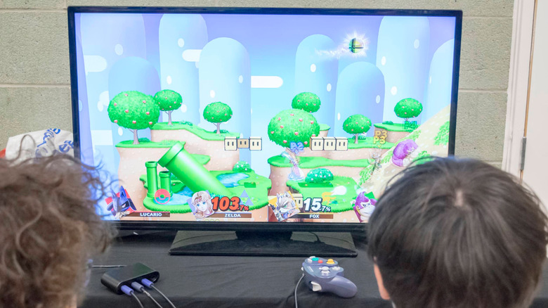 Kids playing Super Smash Bros on the Nintendo GameCube infront of a TV