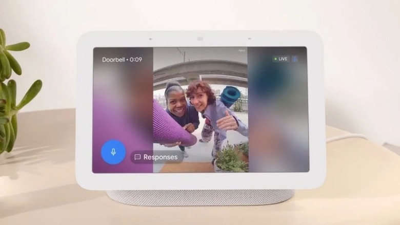A Google Nest Hub 2nd Gen on a table next to a plant