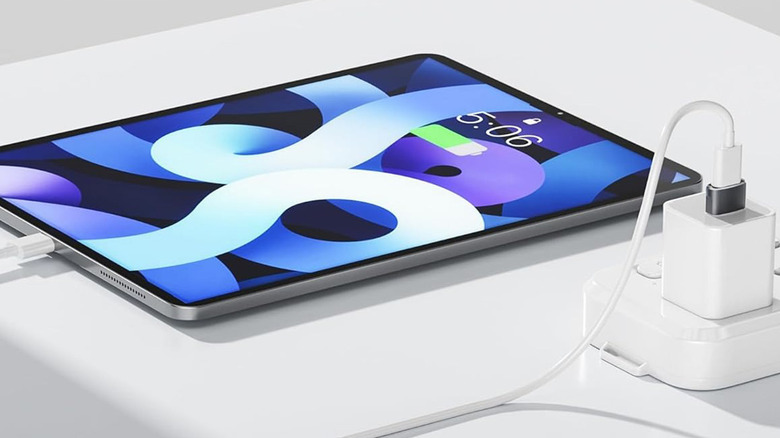 A tablet plugged into a surge protector and charging block.