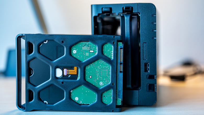 An opened NAS enclosure with a removable disk in front of it.