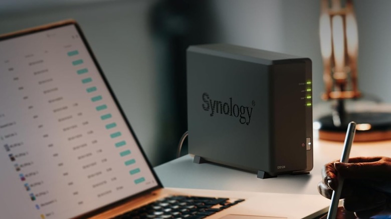 The Synology DS124 set up next to a laptop opened to a document.