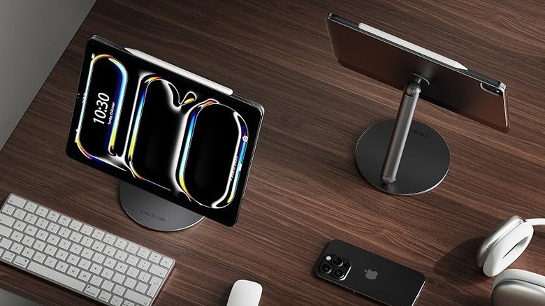 Two iPads attached to LuluLook Magnetic Stand placed on a table with Apple accessories around