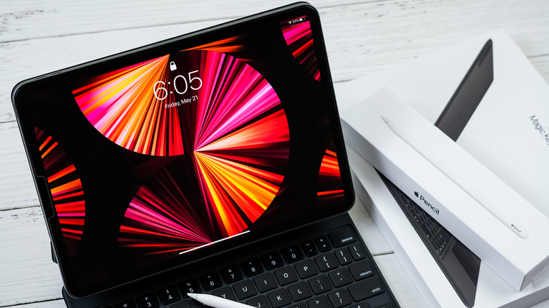 iPad on a keyboard case with Apple Pencil and Magic Keyboard boxes beside it.