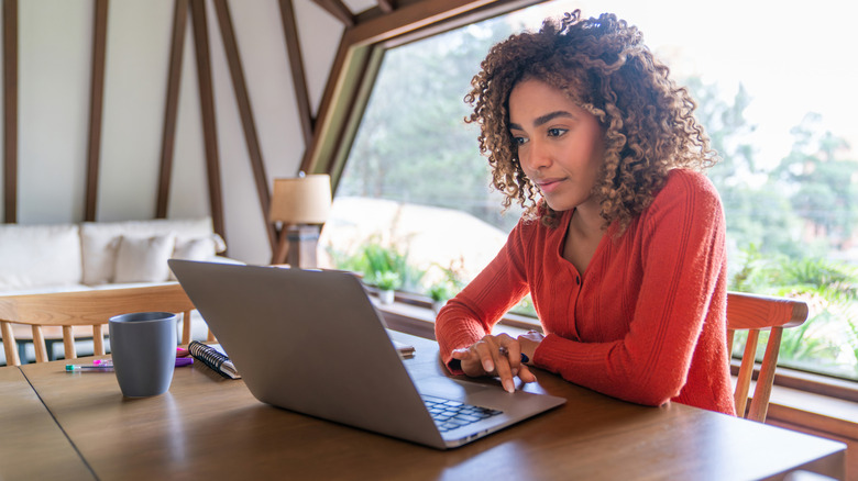 A woman using a laptop.