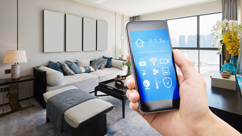 Smart phone displaying smart home system, a luxury apartment is in the background