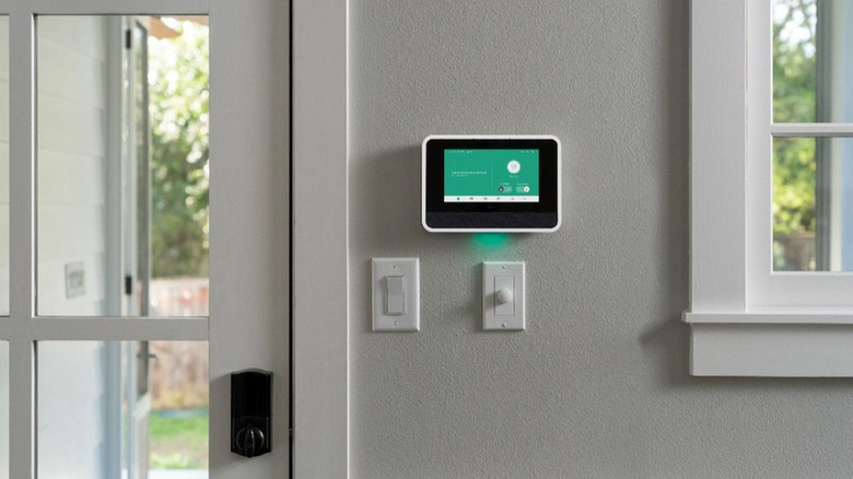 Vivint Smart Home hub on a wall next to a door fitted with a Vivint smart lock