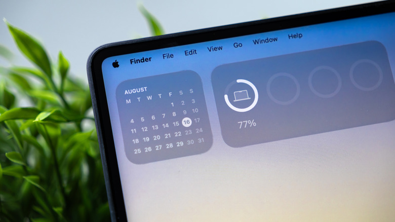 A photograph showing a MacBook with the Batteries and Calendar widgets on the desktop.