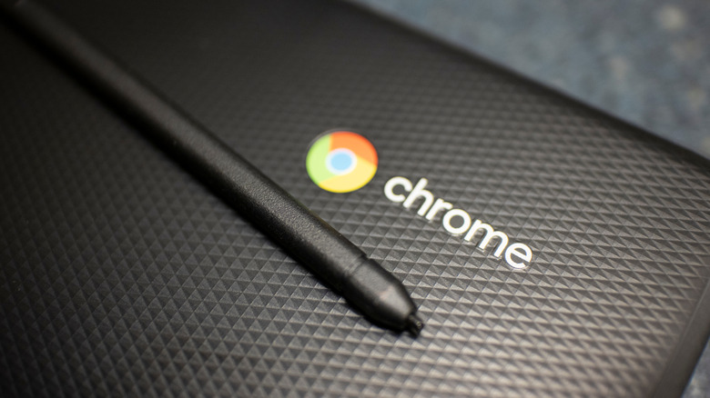 A Chromebook with Chrome icon and a stylus on top