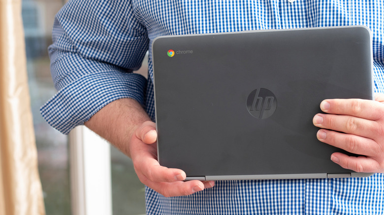 A person holds an HP Chromebook using two hands.
