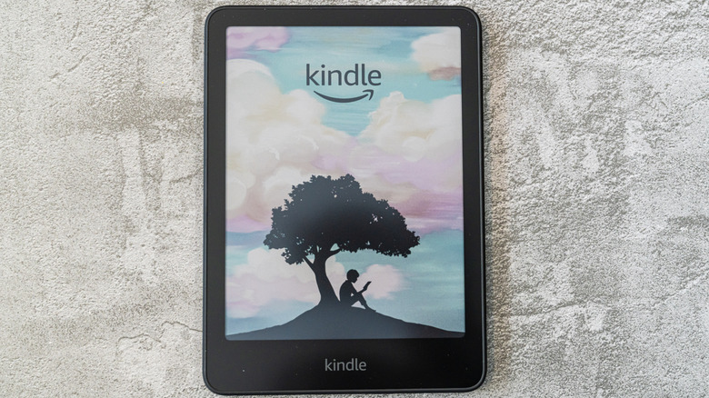 Kindle Colorsoft e-reader showing a color lock screen on a textured gray surface.