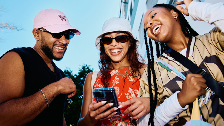 People smiling looking at a phone