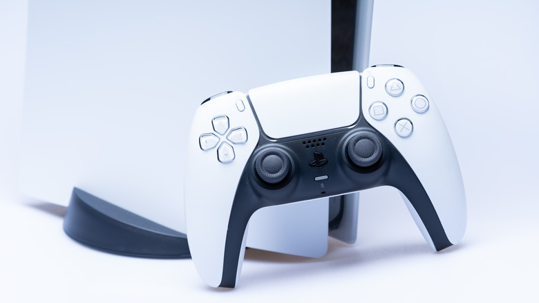 A DualSense controller infront of a PlayStation 5 console