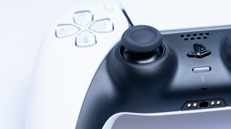 A close up of a DualSense controller showing the left thumb stick