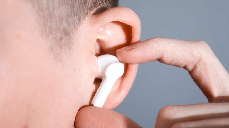 Close-up of person holding earbud in ear