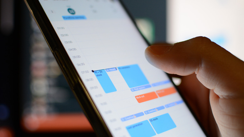A person tapping on the screen to make an edit or view an entry on the calendar app on their phone