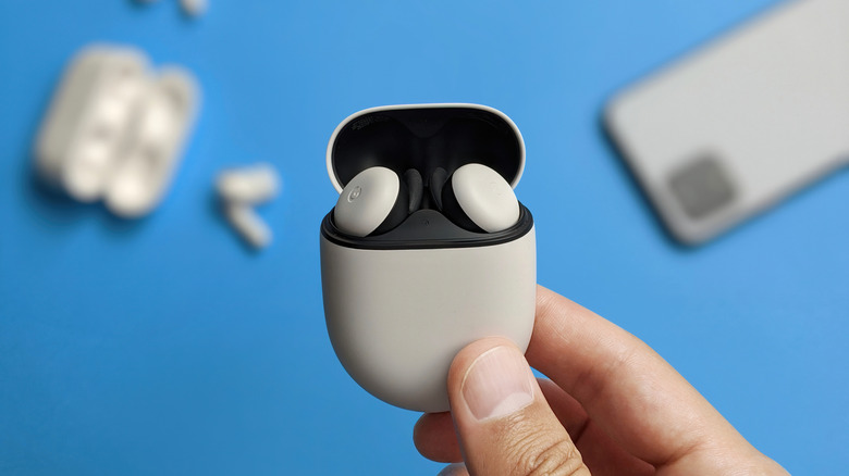 close-up of hand holding pixel buds pro 2 in case