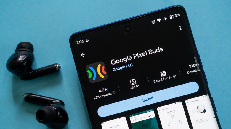 pixel buds 2 earbuds next to a smartphone showing the pixel buds app