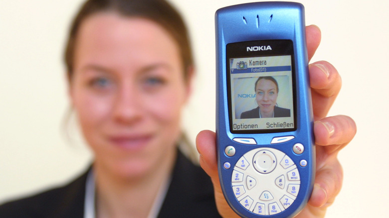 Nokia 3650 held in hand with screen facing camera showing round dialpad