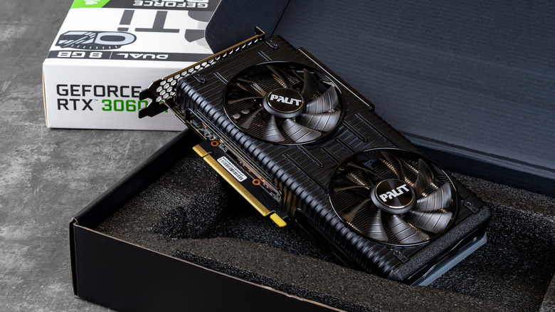GeForce RTX 3060 graphics card resting inside its open box with dual cooling fans visible