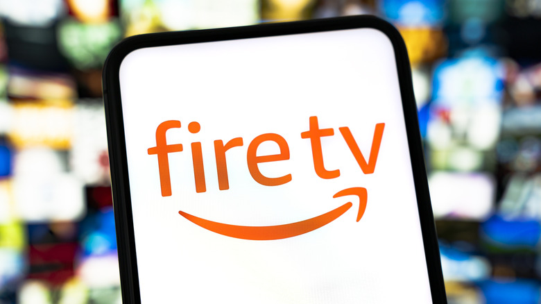 The Fire TV logo on a mobile device with screens in the background