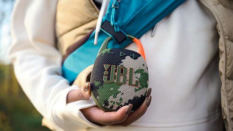 Camo JBL Clip 5 attached to backpack