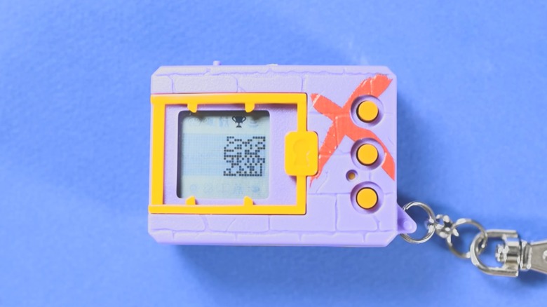 Lavender Digimon X digital pet keychain in front of a lavender background