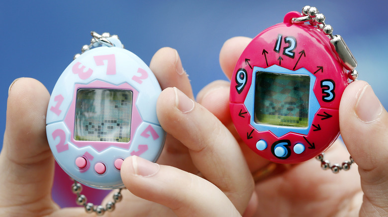 Children holding Tamagotchi digital pet keychains