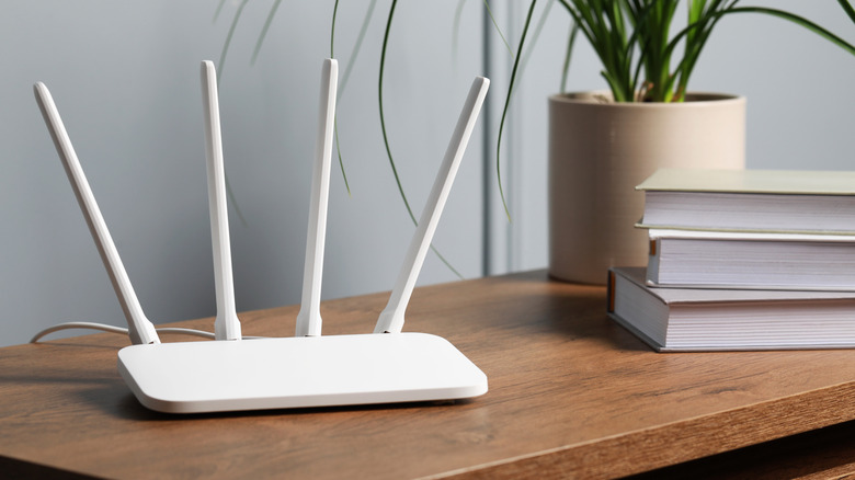 A standalone router placed on a wooden shelf.