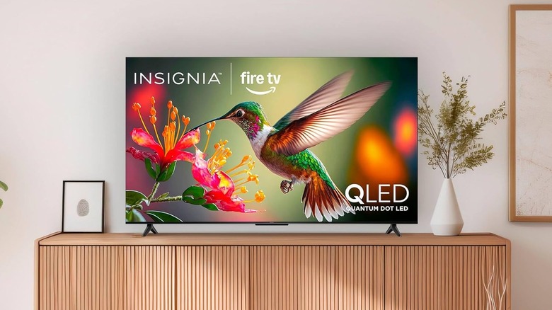 The Insignia UQFL26 set up on a TV stand in a modern living room.