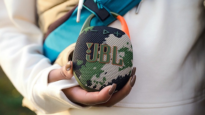 JBL Clip 5 attached to the backpack of a person