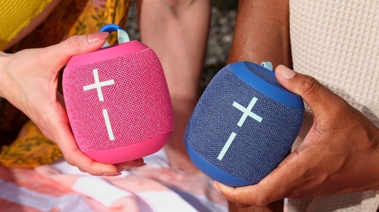 Two hands holding the Ultimate Ears Wonderboom 4 speaker in two colors