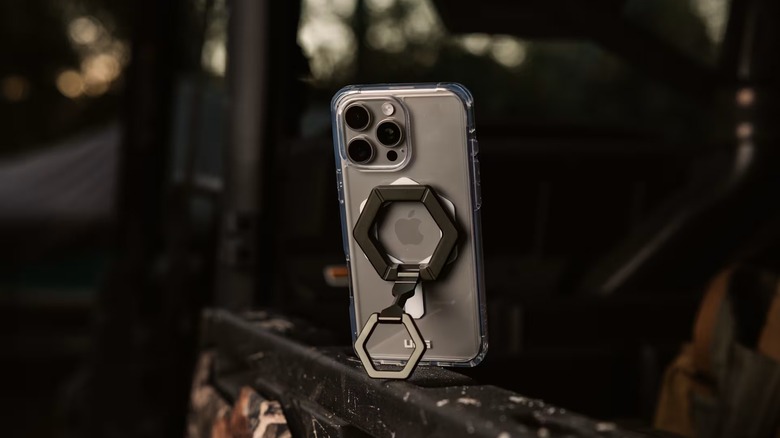 An iPhone with an UAG case and a ring propped up on a surface