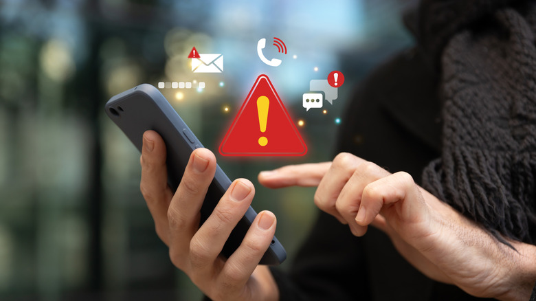 A concept image of a person using a smartphone and dealing with potential security threats.