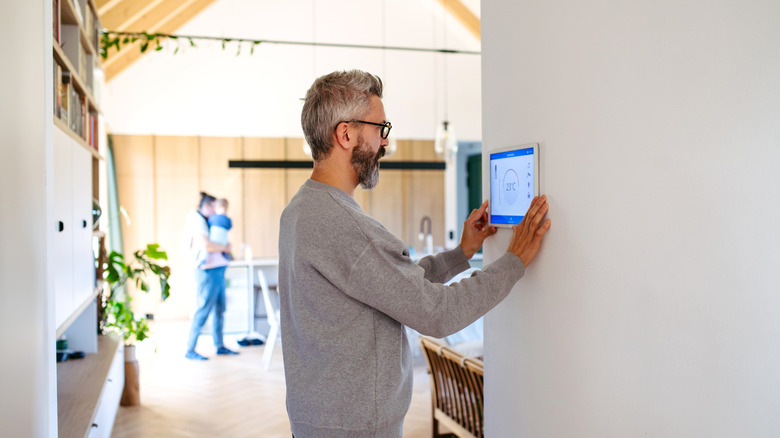 A man setting up a smart home control panel.